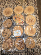 Twelve individually wrapped baked cookies, including several Oatmeal raisin chocolate chips, Snickerdoodles, and a colorful sprinkle Cookie